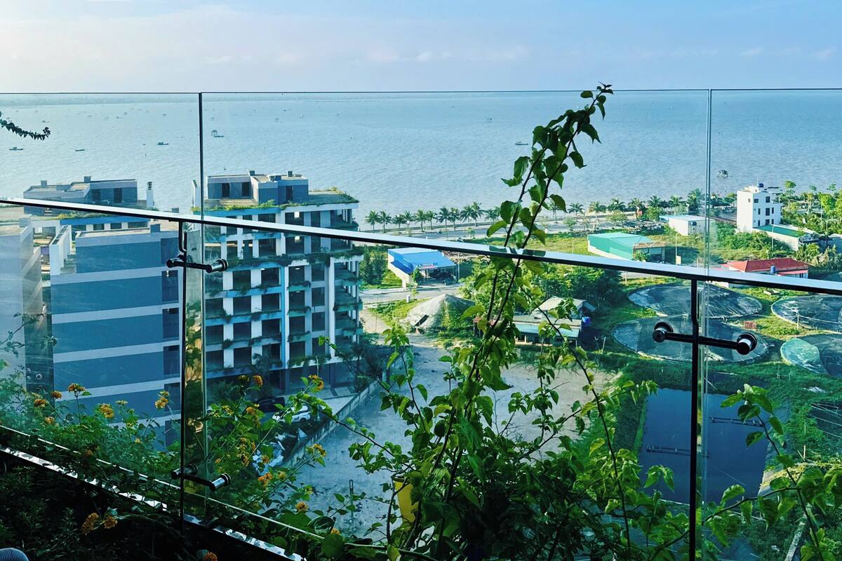 A high-rise building with a view of the sea and other buildings.