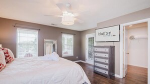 A bedroom with a bed, a dresser, a ceiling fan, and a framed sign on the wall. - Bluffton Magnolia House (Bluffton)