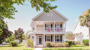 A two-story house with a front porch, a balcony on the second floor, and a small front yard. - Bluffton Magnolia House (Bluffton)