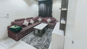 Una sala de estar moderna con un sofá seccional, una mesa de centro y un tapete estampado.