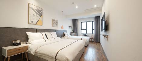 A modern hotel room with a large bed, bedside tables, a TV, and a window with curtains.