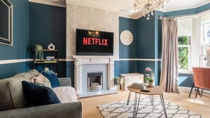 A living room with a fireplace, a television mounted above it, and a sofa. - Beautiful Townhouse Harrogate, 3 bedroom (Harrogate)