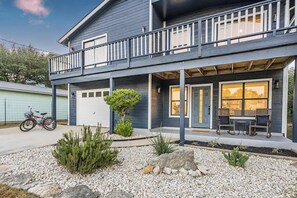 A two-story house with a balcony, a garage, and a patio with seating. - Stagecoach Breeze | Lake View•Firepit•Pet Friendly (Canyon Lake)