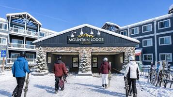 Un edificio con la scritta 'Mountain Lodge' e una seggiovia sullo sfondo.