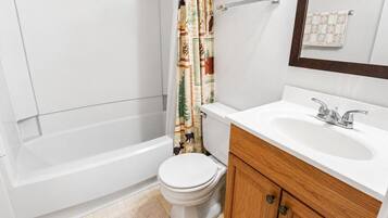 A bathroom with a toilet, a bathtub, and a sink.