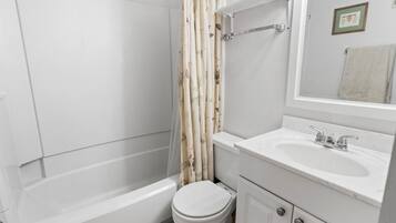A bathroom with a bathtub, toilet, and sink.