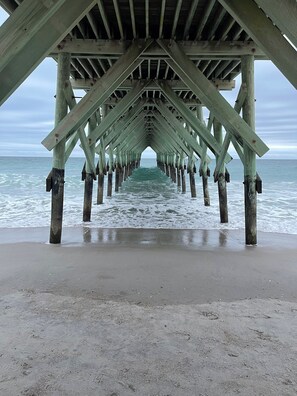Un muelle de madera que se adentra en el océano, con una vista despejada del agua.