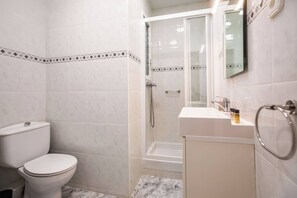 Une salle de bain avec des toilettes, une douche et un lavabo.