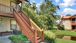 A two-story house with a wooden staircase leading to the upper floor. - Nice 3 bedroom condo located in Harbour Oaks (Saint Simons Island)