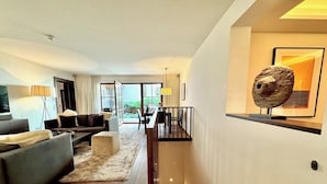 A modern living room with a sofa, coffee table, and a staircase leading to an upper level. - Exclusive deluxe suite in the heart of Kitzbühel (Kitzbühel)