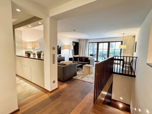 A modern interior with a kitchen, living area, and staircase.
