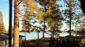 Une vue sur un lac, avec des arbres et une maison au premier plan.