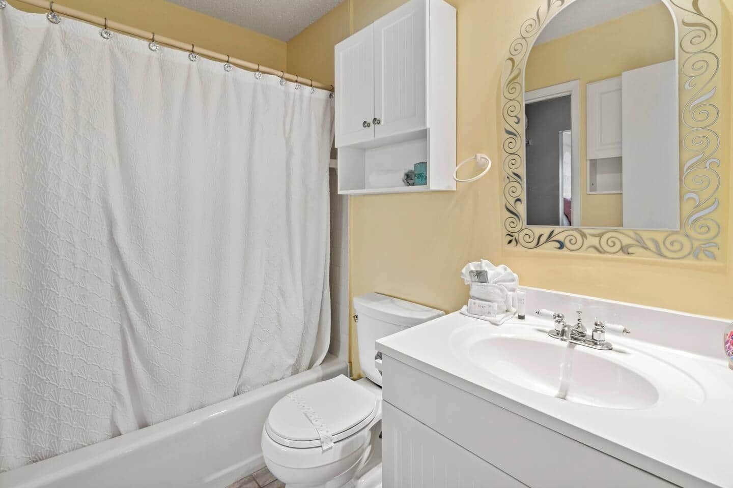 A bathroom with a bathtub, toilet, and sink.