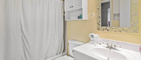 A bathroom with a bathtub, toilet, and sink.