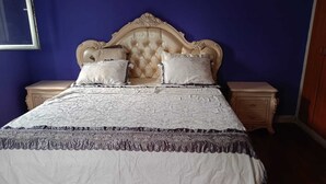 A bedroom with a tufted headboard, two bedside tables, and a bed with a patterned bedspread. - Luanda, Angola! Next to the Multipurpose Pavilhao! Centralidade do Kilamba, block M15 (Kilamba)