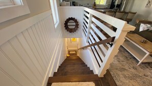 Een trap met witte leuningen en een houten handrail, leidend naar een verdieping.