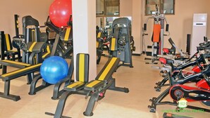 A gym with various exercise equipment, including weight machines, a treadmill, and exercise balls. - Hunters Royal Apartments (Madina)