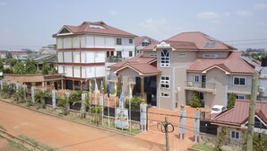 A residential area with houses featuring red-tiled roofs and a mix of architectural styles. - Hunters Royal Apartments (Madina)