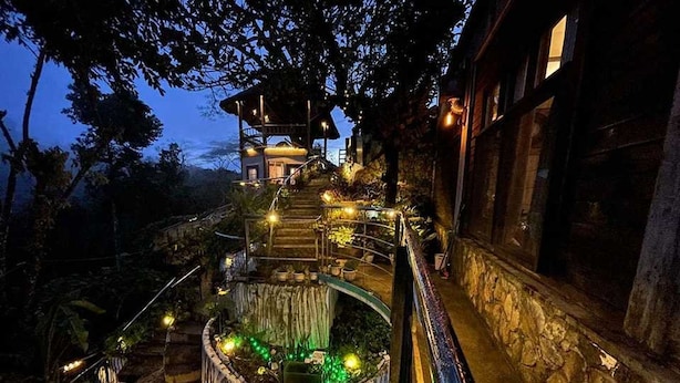 A multi-level outdoor staircase with a wooden deck and railing, leading to a structure with a roof. - OYO 1173 Sermon On The Mount Retreat (Balamban)