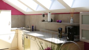 A modern kitchen with skylights, a dishwasher, a coffee maker, and a small shelf with decorative items. - Ferienwohnung in Freital, Dresden (Freital)
