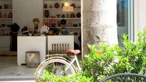 Una tienda con estantes llenos de cerámica y una bicicleta al frente.