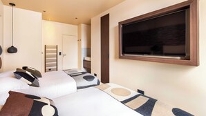 A hotel room with two beds, a large window, and a flat-screen TV mounted on the wall. - Gorgeous Apartment - 2br/8p - Le Marais (Paris)