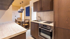 A modern kitchen with wooden cabinets, a marble countertop, a built-in oven, and pendant lighting. - Gorgeous Apartment - 2br/8p - Le Marais (Paris)