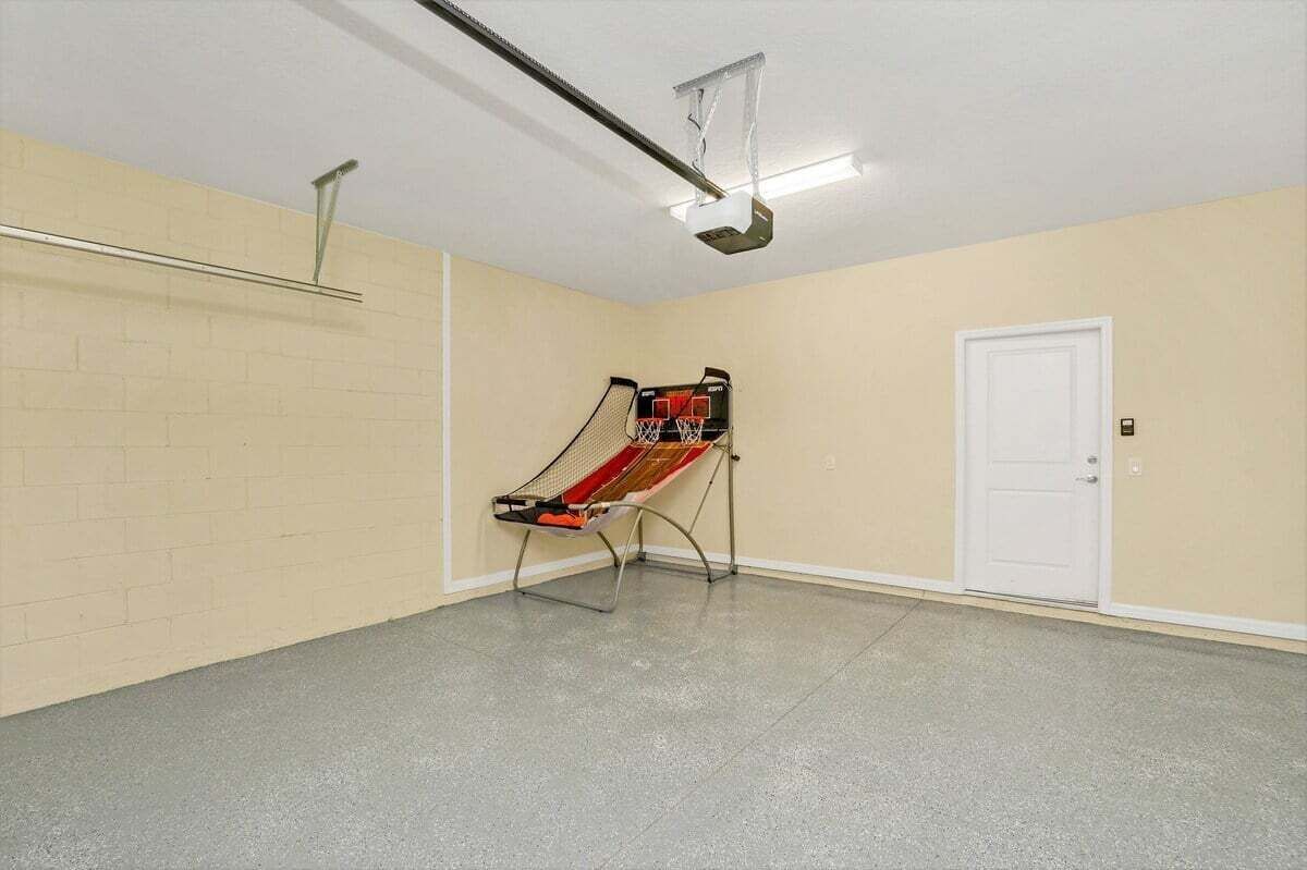 A basketball court with a hoop, a door, and a light fixture.