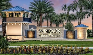 A resort sign with "Windsor Island Resort" written on it, surrounded by palm trees and a well-maintained lawn. - Last Minute Disney Getaway! Private Pool & Themed Bedrooms. Book Now! #118521 (Orlando)