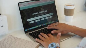 Een laptop op een tafel met een open webpagina waarop 'CASAS TROPICAL' staat.
