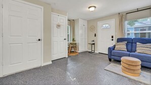 A living room with a blue sofa, a small table, and a door labeled "laundry".