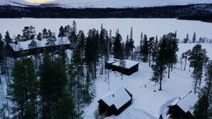 Un paisaje nevado con cabañas y un bosque denso.