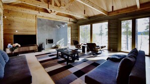 Un salón amplio con un gran ventanal, chimenea y un rincón de estar acogedor.