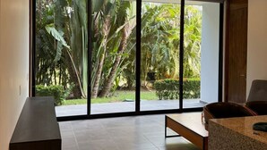 Une chambre moderne dotée de grandes portes-fenêtres coulissantes donnant sur un jardin.