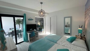 A modern bedroom with a large bed, a desk, and a television. - MarVillaFuerte - One Bedroom Apartment, Sleeps 4 (La Oliva)