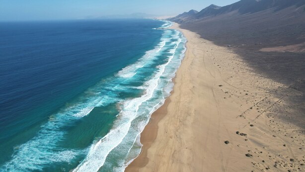 A coastal landscape with a beach, ocean, and mountains. - MarVillaFuerte - One Bedroom Apartment, Sleeps 4 (La Oliva)