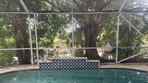 A swimming pool with tiled steps and a metal structure overhead. - 4-bedroom 3 bathroom room house with AC with Private Pool in great Pompano Beach (Pompano Beach)