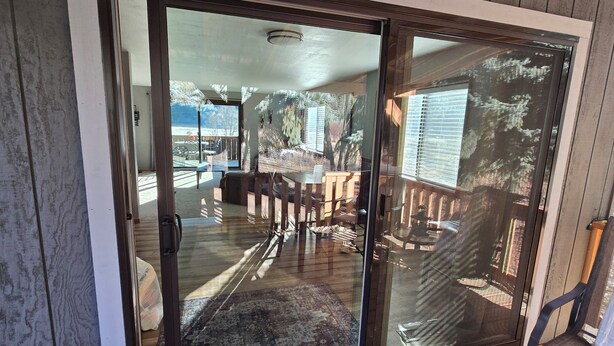 A sliding glass door leading to a patio area with outdoor furniture and a view of the backyard. - Country Living 6 miles from Colville, easy access, on a beautiful large pond! (Colville)