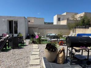 A patio with outdoor furniture, a barbecue grill, and a hot tub.