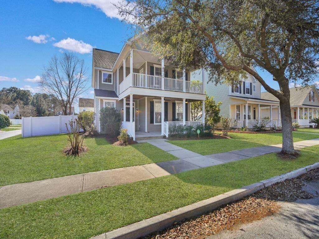 A two-story house with a front porch and a balcony on the upper floor.