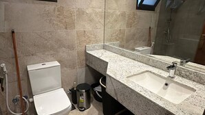Moderni kylpyhuone, jossa on wc, pesuallas ja suihku.