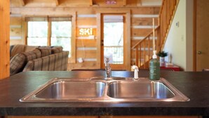 A kitchen with a double sink, a wooden ceiling, and a neon sign in the background. - DreamForest 3BR, Firepit, Foosball, Banner Elk (Banner Elk)