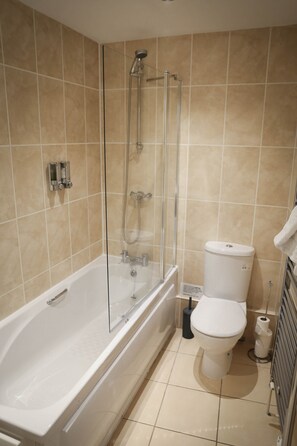 Une salle de bain avec une baignoire, des toilettes et une douche.