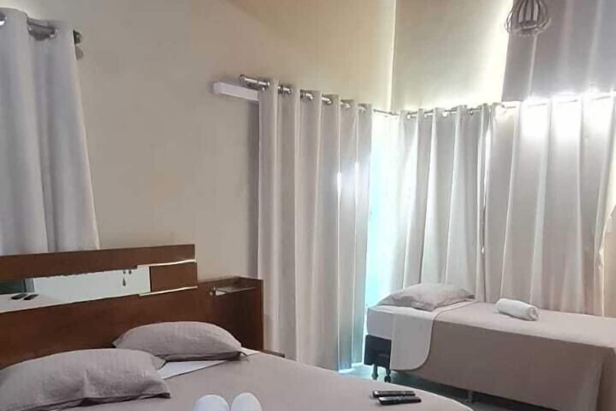 Ein Hotelzimmer mit einem großen Bett, einem kleinen Sofa und einem separaten Schlafbereich.