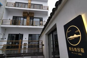 A building with a balcony and a sign with Chinese characters.