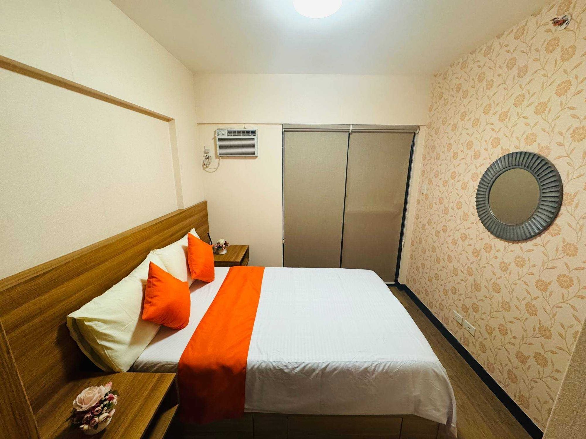 Una habitación de hotel con cama, mesita de noche y armario.