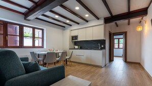 Une cuisine moderne avec des armoires blanches, un plan de travail noir et un four à micro-ondes encastré.