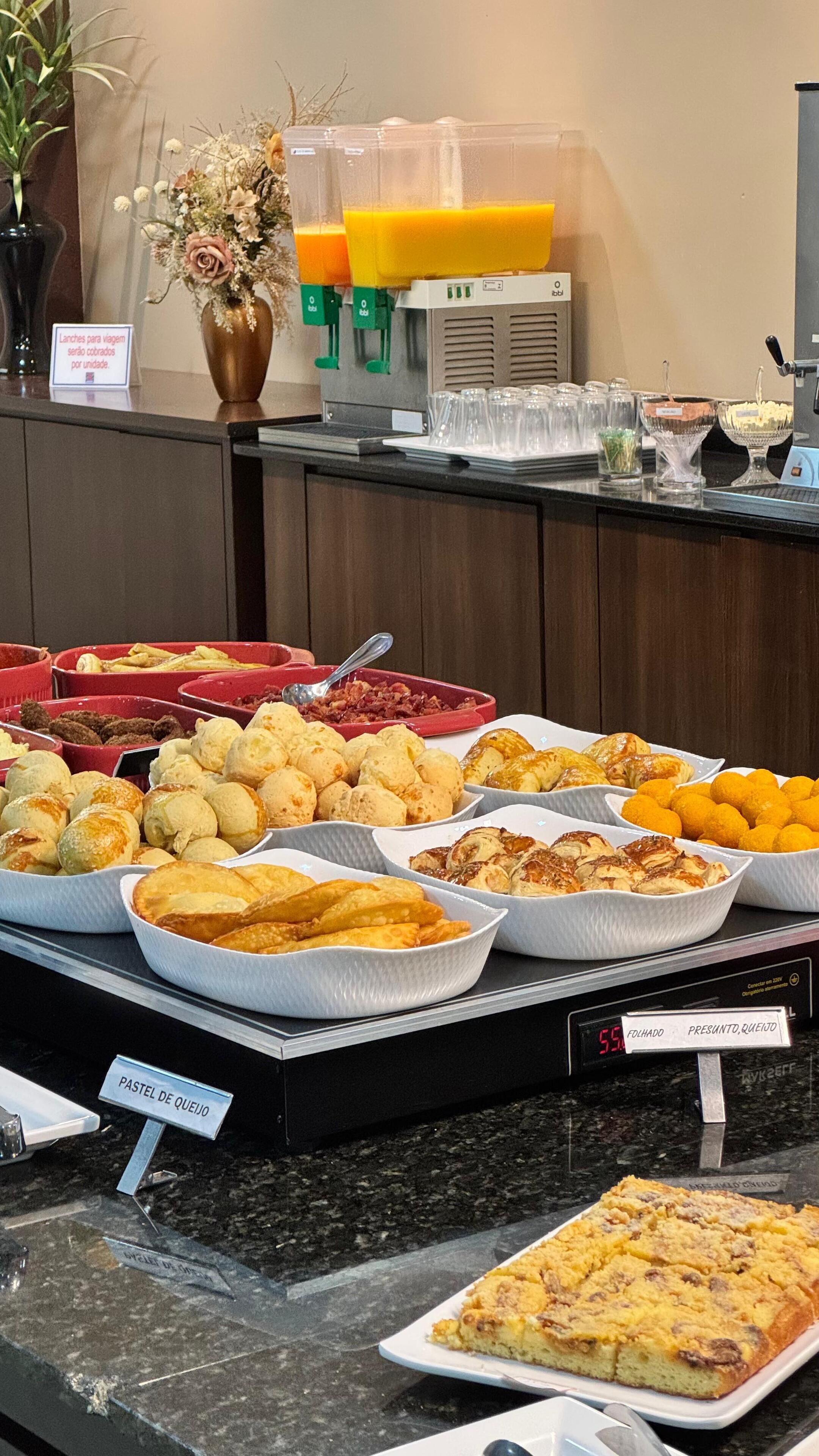 Un bufé con diversas opciones de comida, incluyendo pasteles, pan y un pastel.