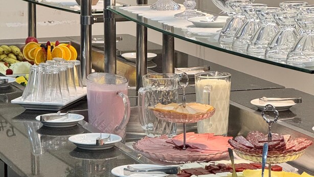 A buffet setup with various food items and beverages. - Hotel Zandona (Blumenau)