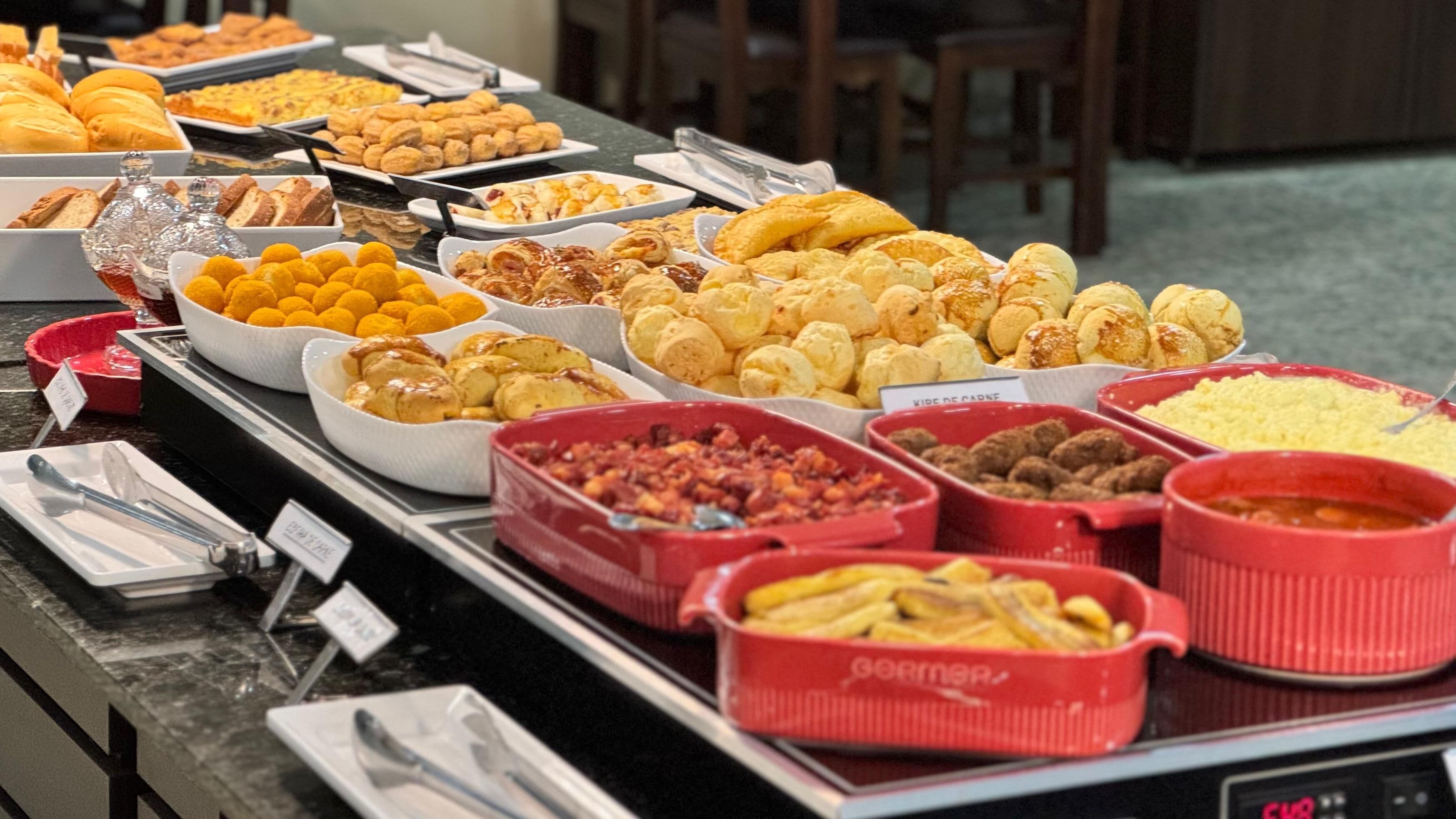 Un bufé con una variedad de alimentos, incluyendo pasteles, frutas y carnes.